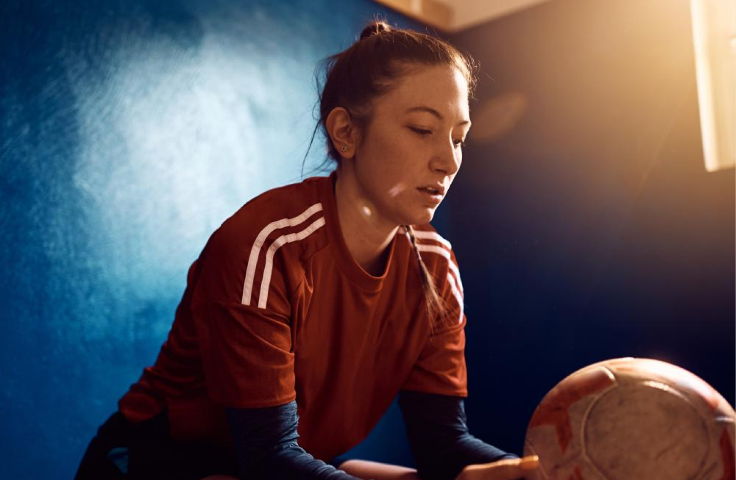 mulher equipada a contemplar bola de futebol